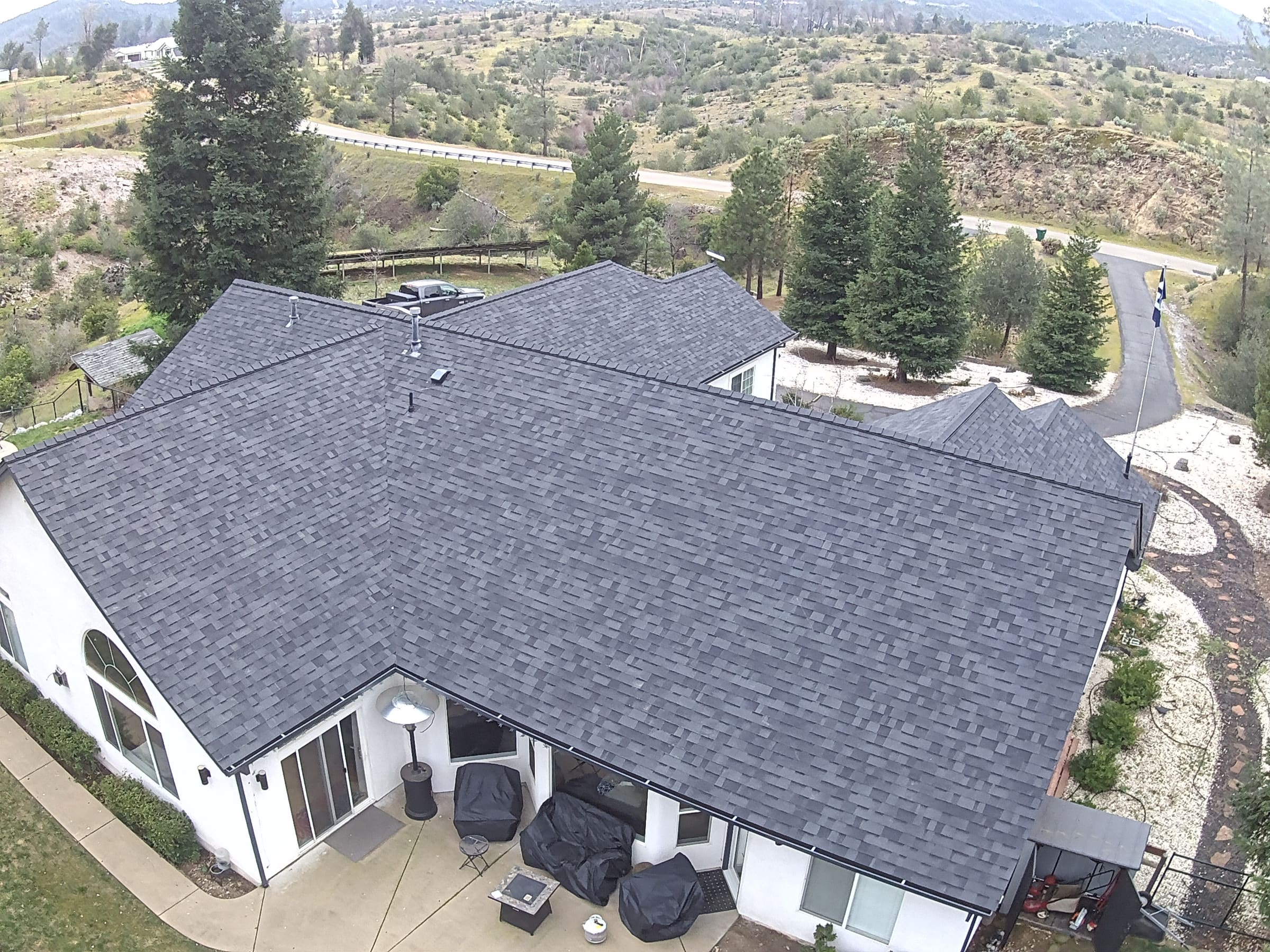 Aerial view of a completed shingle re-roof on a large Redding-area home