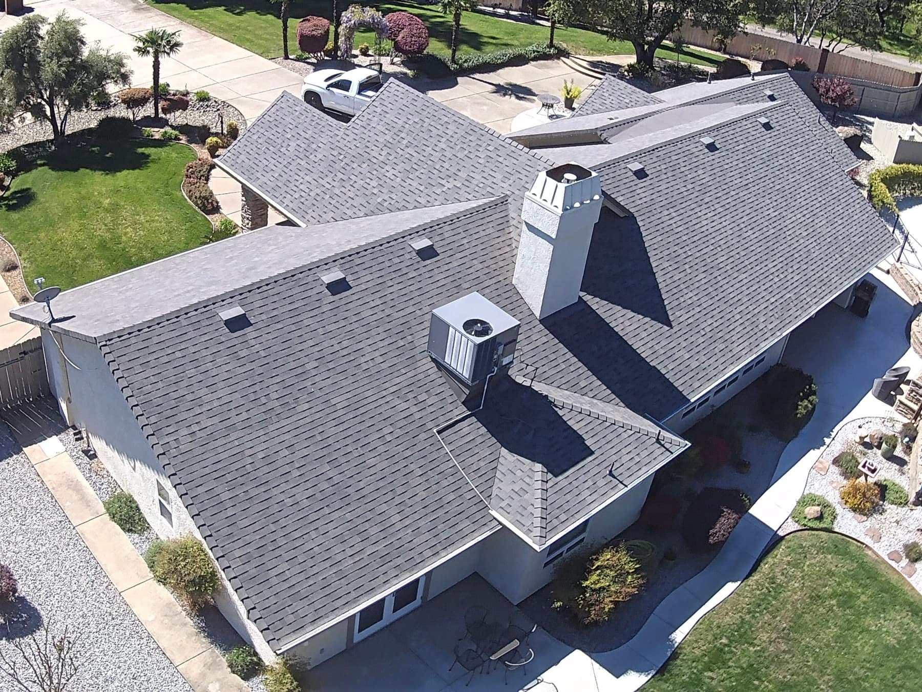 Aerial view of a large finished shingle roof with a circular driveway