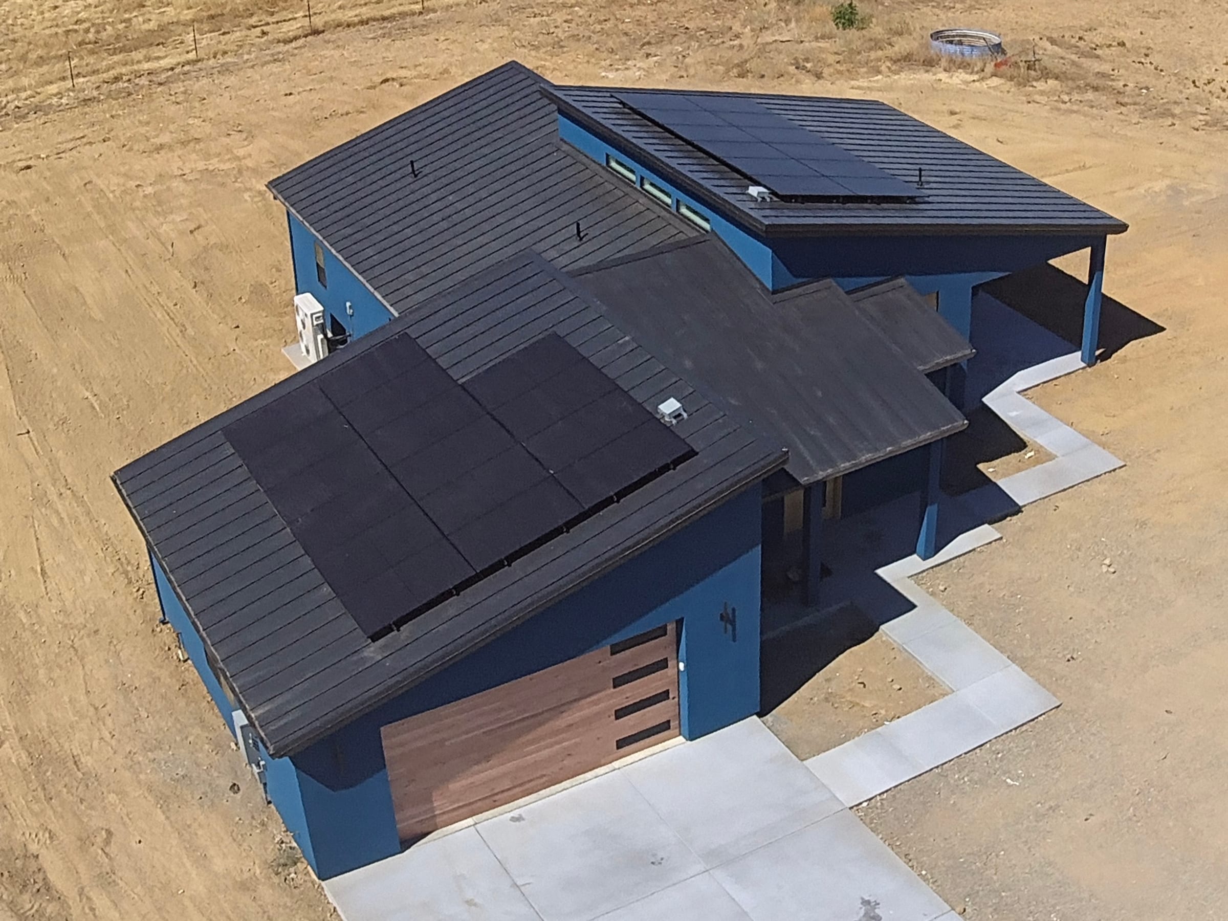 Aerial view of a multi-gable standing-seam metal roof with solar panels