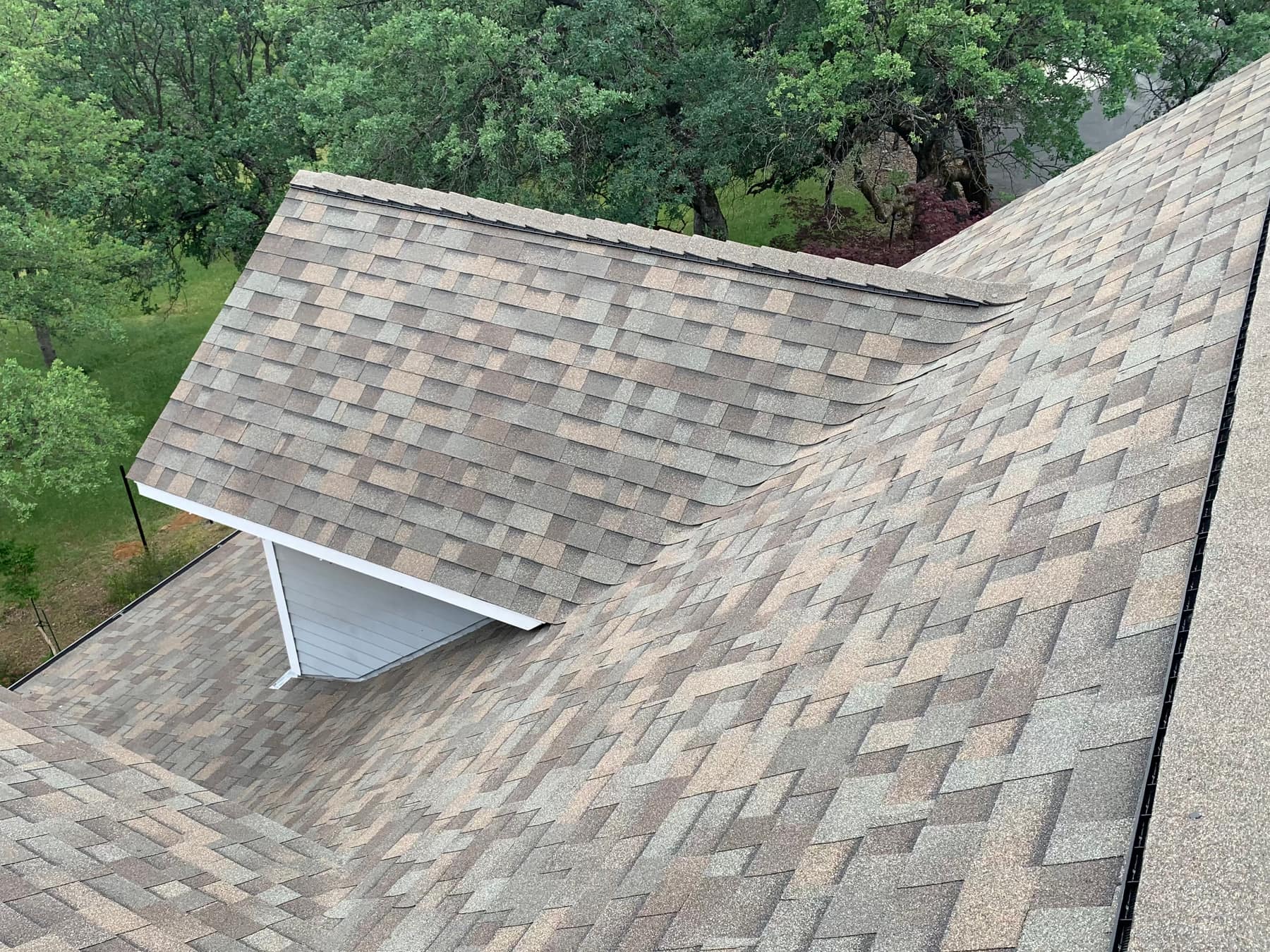 Aerial view of a finished shingle roof with a dormer
