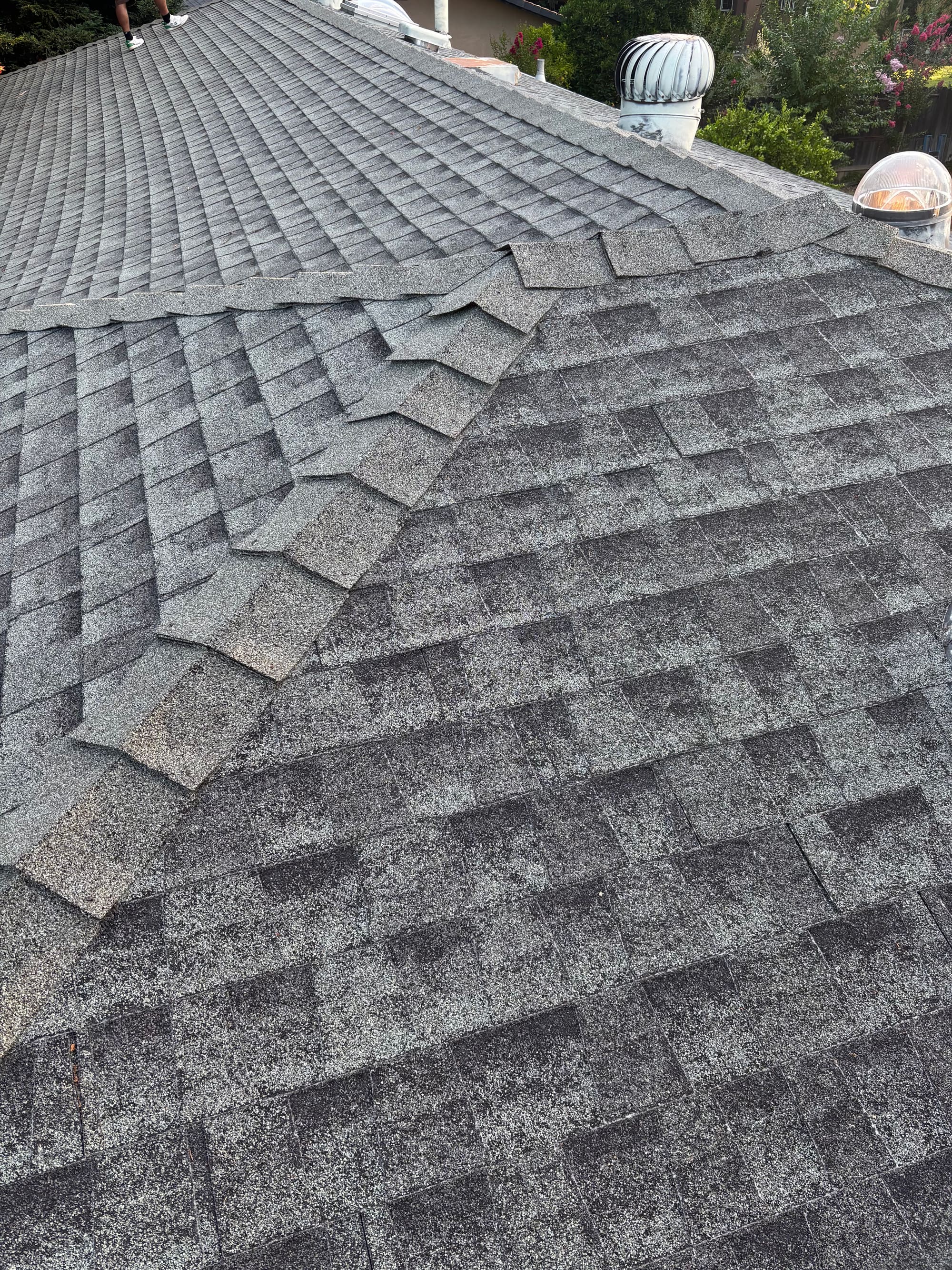 Aerial view of an aged roof with mismatched shingles before a full re-roof
