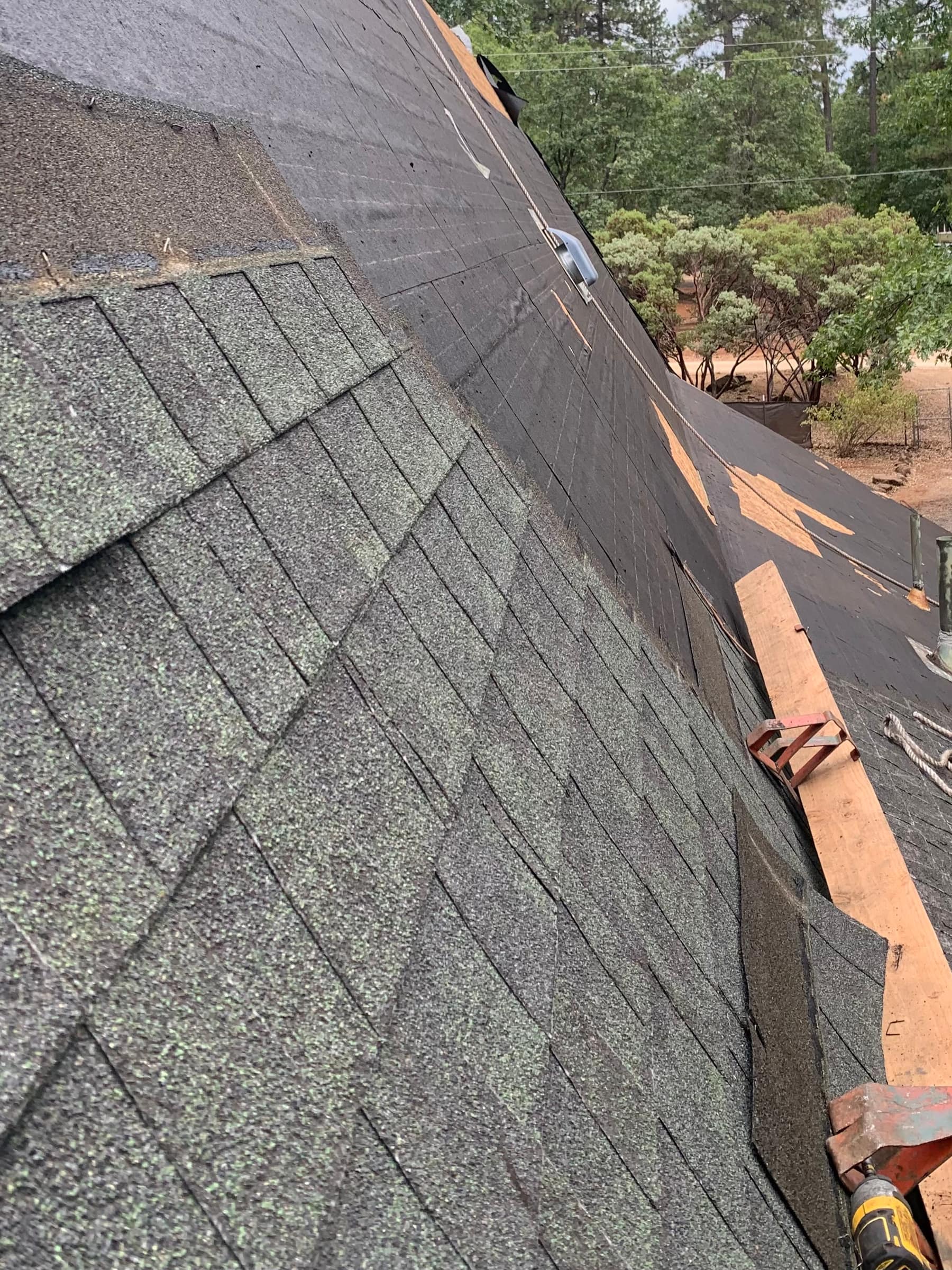 Roof tear-off in progress showing exposed felt and decking