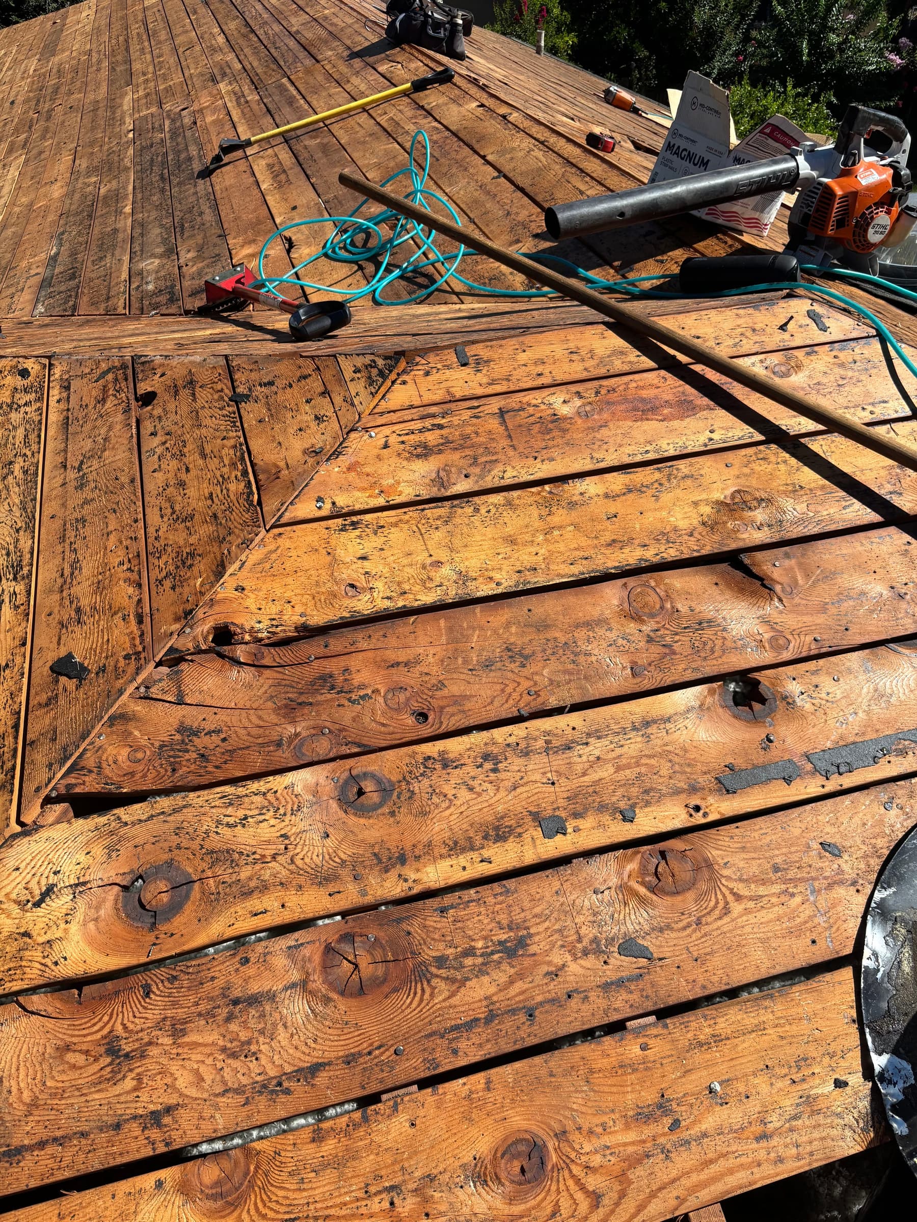 Bare roof decking exposed after a full tear-off, ready for repairs